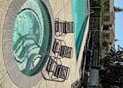 Thumbnail 6 of 14 - A small pool with a fountain in the middle.