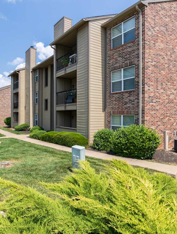 A large apartment building with a grassy lawn in front