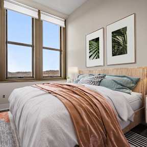 a bedroom with a bed and three windows