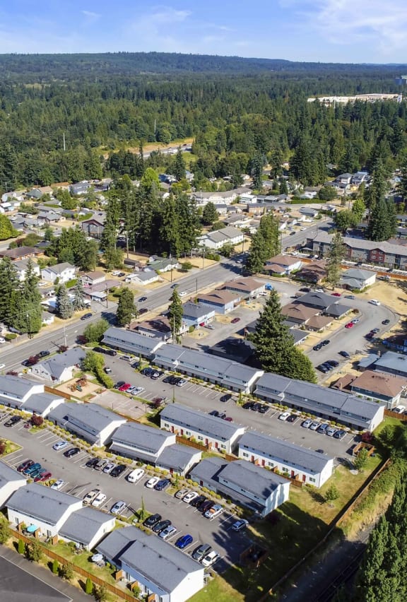 Exterior community ariel view, property is lined with trees, grass, and mountain tops in the background.at Quilceda Gardens, Washington, 98270