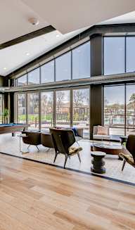 a large open living room with a pool table and a kitchen