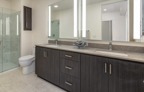 a bathroom with a large mirror and a toilet and a shower