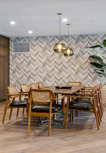 A dining room with a wooden table and chairs.