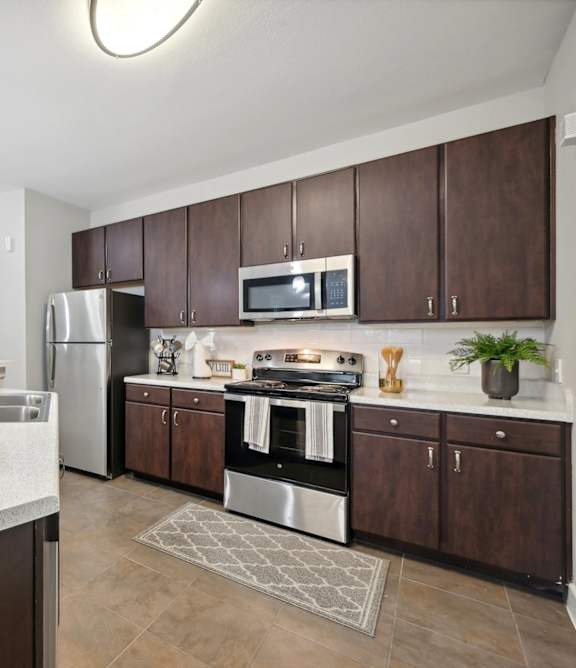 A kitchen with brown cabinets and a white counter.