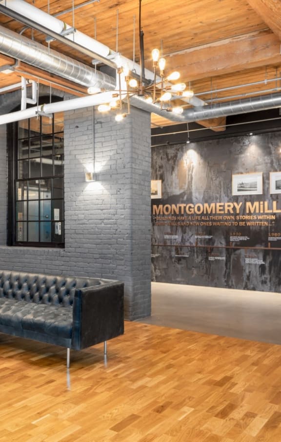 a large room with couches and a table at Montgomery Mill Apartments in Windsor Locks, CT