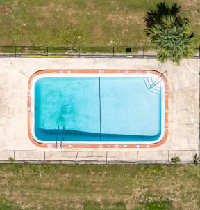arial view of a swimming pool in the middle of a grassy area