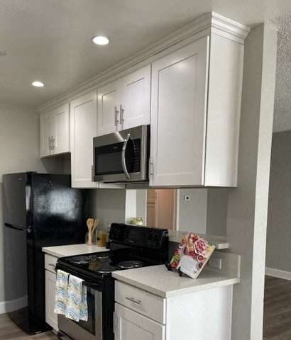 Kitchen with stove, fridge, and microwave