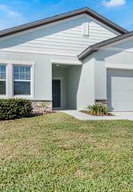 A two-story house with a garage and a driveway.