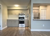 Thumbnail 12 of 12 - A kitchen with a white tile backsplash and wooden floors.