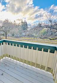 A deck with a view of a tree-lined field.
