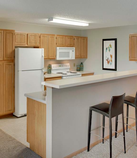 A modern kitchen with white appliances and wooden cabinets.