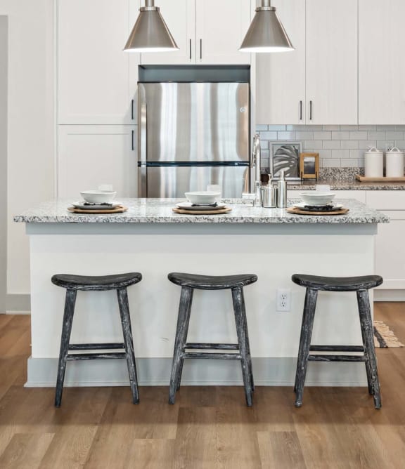 an open kitchen with a center island and three stools