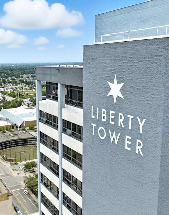A tall building with a sign in front of it.