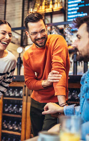 Four people are sitting at a table in a bar.