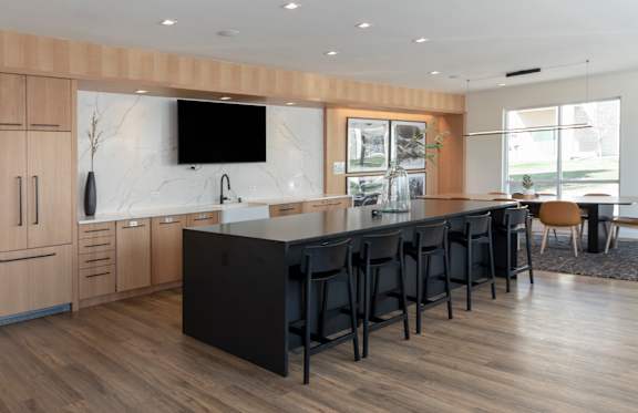 A modern kitchen with wooden cabinets and a black counter.