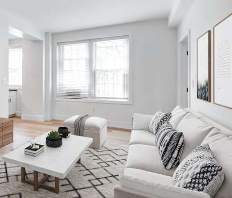 a living room with a white couch and a tv