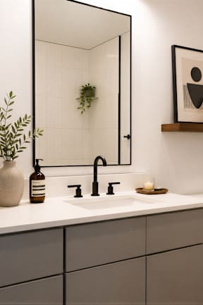 A bathroom with a white countertop and a white toilet.