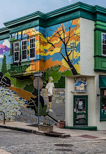 A building with a mural of a tree on its side.