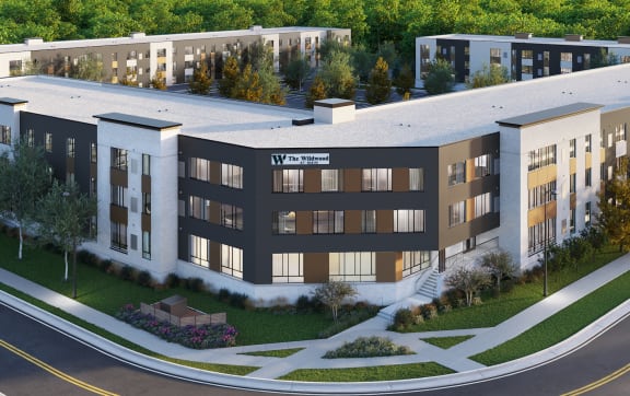 an aerial view of an apartment complex with trees in the background