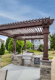 A patio with a pergola and a chair is shown.