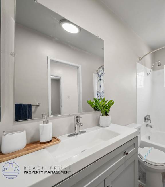 A bathroom with a white toilet, sink, and shower curtain.