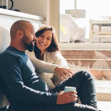 a couple sitting down on the floor having a conversation