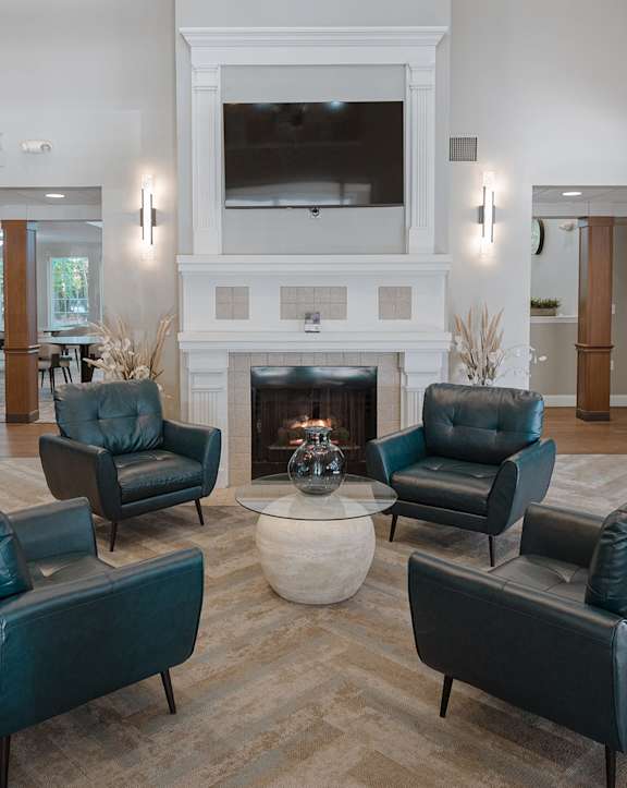 A living room with a fireplace and a TV mounted above it.