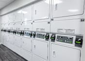 Thumbnail 5 of 10 - a row of washers and dryers in a utility room