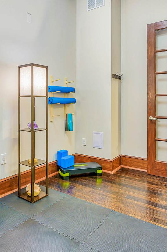 a workout room with treadmills and a tv at The Lofts at Reynolds Village Apartments, Asheville