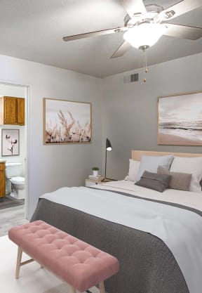 a bedroom with an orange accent wall and a bed with a white comforter and colorful