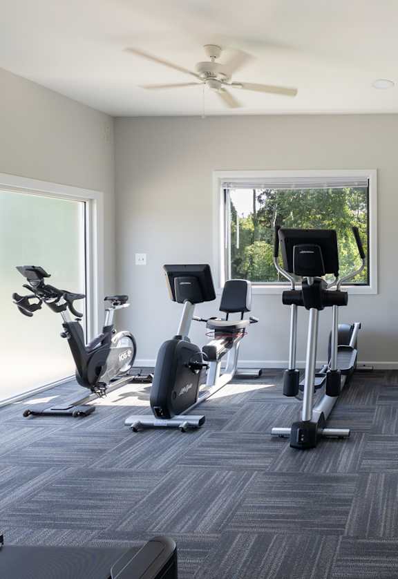 A spacious gym with a variety of equipment including treadmills, stationary bikes, and weight machines.