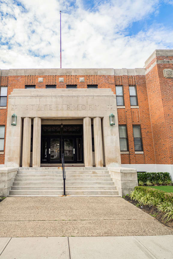 a large brick building with stairs in front of it at Retro 511 Apartments, West Haven, Connecticut