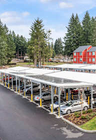 A parking lot with cars and a building in the background.