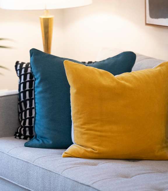 a couch with blue and yellow pillows on it at Parc 1346, Chattanooga, Tennessee
