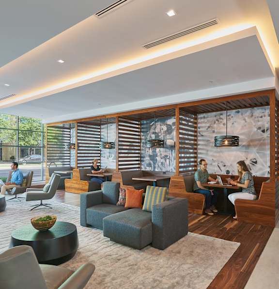 A modern living room with people sitting and chatting.