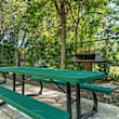 A wooden deck with lounge chairs and umbrellas in front of a building.