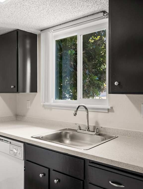 an empty kitchen with a sink and a window