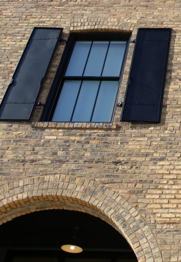 Window Panels with Black Shutters on Brick Exterior at 700 Central, Minneapolis, MN, 55414