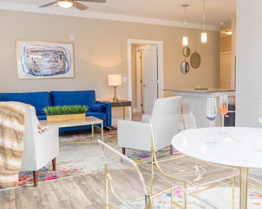 A living room with a blue couch and a white coffee table.