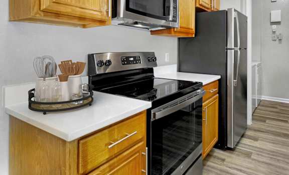 a kitchen with black appliances and wooden cabinets at Grandeville on Saxon, Orange City, Florida