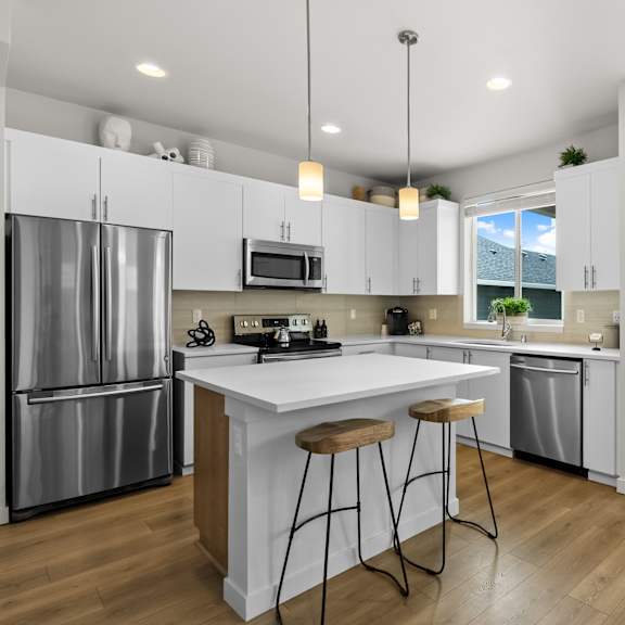 A modern kitchen with white cabinets and a central island.