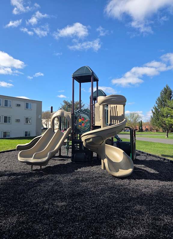 A playground with a slide and a tower.
