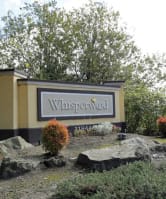 a sign for the sign in front of some rocks at Whisperwood, Seattle, Washington