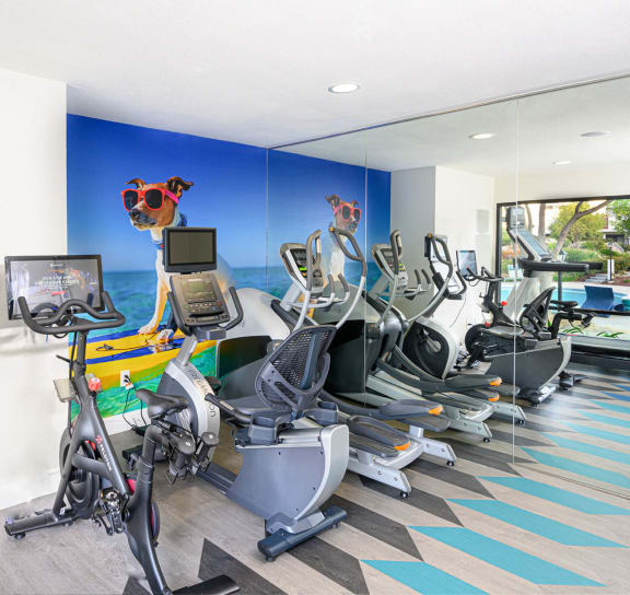 a gym with various cardio machines and a water fountain at Sendero Huntington Beach, Huntington Beach California
