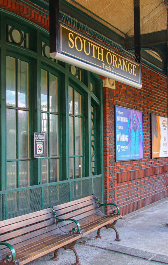 A sign at a train station directs passengers to the trains going to Newark/Hoboken and New York.