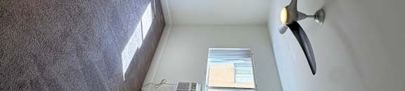 A room with a ceiling fan and a skylight.