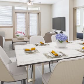 a dining room with a table and chairs and a tv in a 555 waverly unit