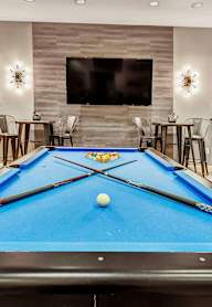 A pool table in a room with a carpeted floor.