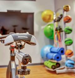A Sennheiser microphone is placed on a stand in a room with a TV and balloons in the background.