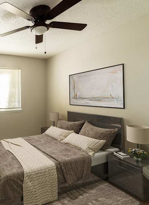A bedroom with a large bed and a ceiling fan.